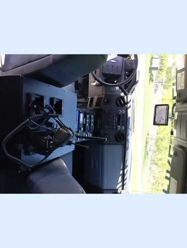 Exterior view of small fire truck showing cab, body compartments, and wheel/tire area.