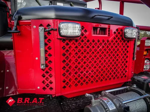 Exterior view of small fire truck showing cab, body compartments, and wheel/tire area.