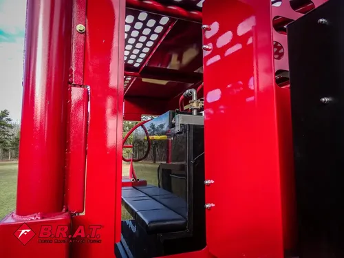 Exterior view of small fire truck showing cab, body compartments, and wheel/tire area.