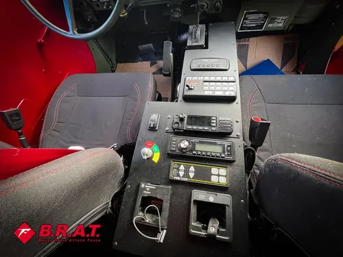 Exterior view of small fire truck showing cab, body compartments, and wheel/tire area.