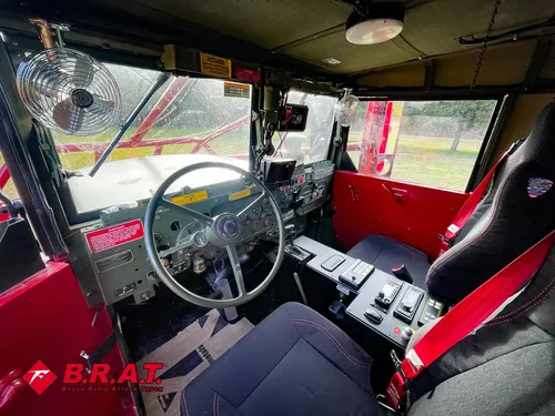 Exterior view of small fire truck showing cab, body compartments, and wheel/tire area.