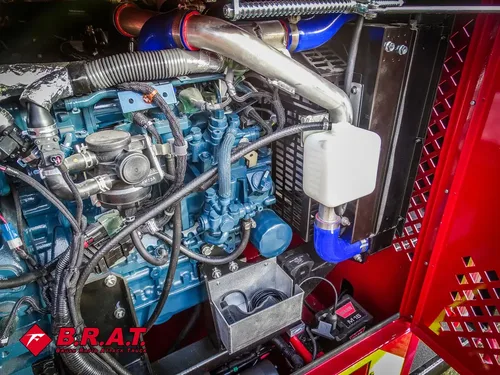 Exterior view of small fire truck showing cab, body compartments, and wheel/tire area.
