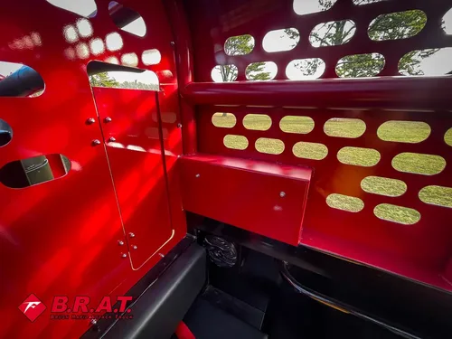 Exterior view of small fire truck showing cab, body compartments, and wheel/tire area.