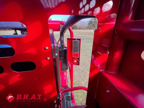 Exterior view of small fire truck showing cab, body compartments, and wheel/tire area.