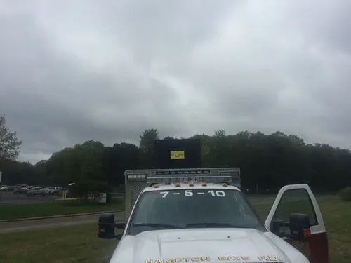 Exterior view of small fire truck showing cab, body compartments, and wheel/tire area.