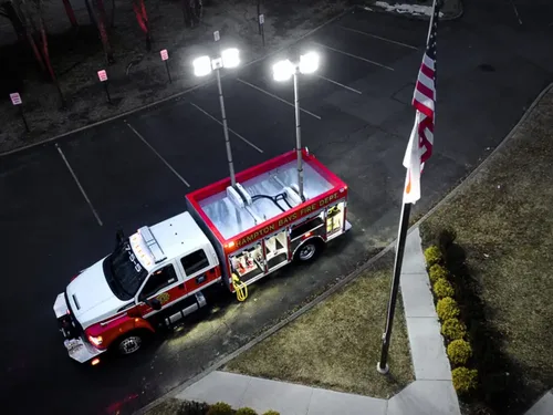 Exterior view of small fire truck showing cab, body compartments, and wheel/tire area.