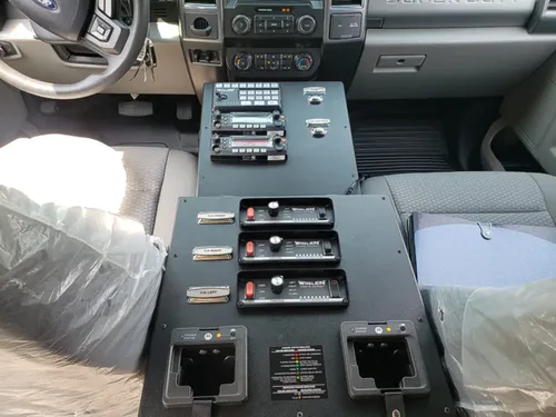 Exterior view of small fire truck showing cab, body compartments, and wheel/tire area.