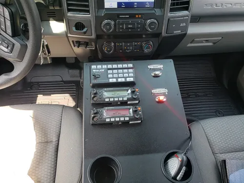 Exterior view of small fire truck showing cab, body compartments, and wheel/tire area.