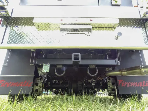 Exterior view of small fire truck showing cab, body compartments, and wheel/tire area.