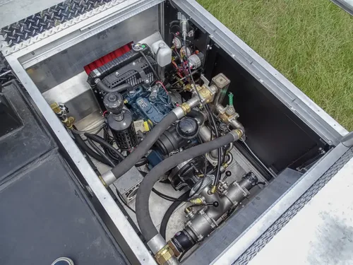 Exterior view of small fire truck showing cab, body compartments, and wheel/tire area.