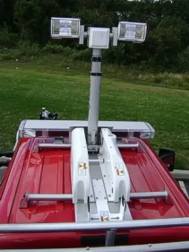 Exterior view of small fire truck showing cab, body compartments, and wheel/tire area.