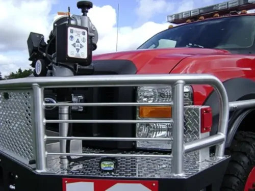 Exterior view of small fire truck showing cab, body compartments, and wheel/tire area.