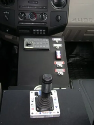 Exterior view of small fire truck showing cab, body compartments, and wheel/tire area.