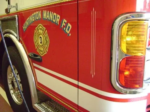 Exterior view of small fire truck showing cab, body compartments, and wheel/tire area.