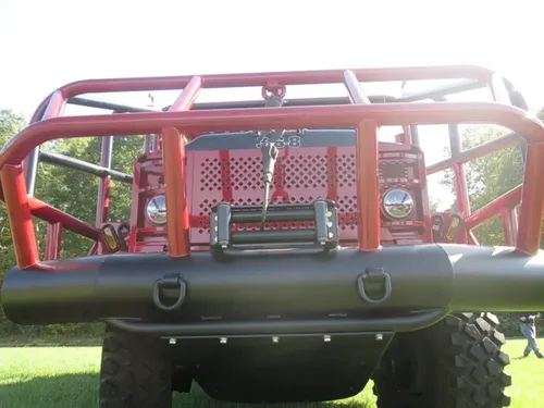 Exterior view of small fire truck showing cab, body compartments, and wheel/tire area.