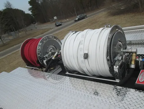 Exterior view of small fire truck showing cab, body compartments, and wheel/tire area.