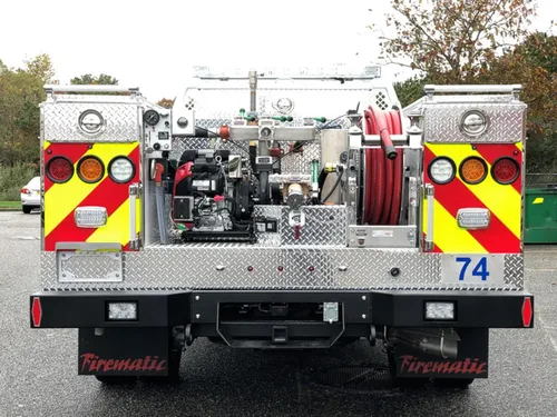 Exterior view of small fire truck showing cab, body compartments, and wheel/tire area.