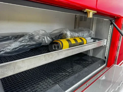 Compartment shelf close-up with tool and protective wrap.