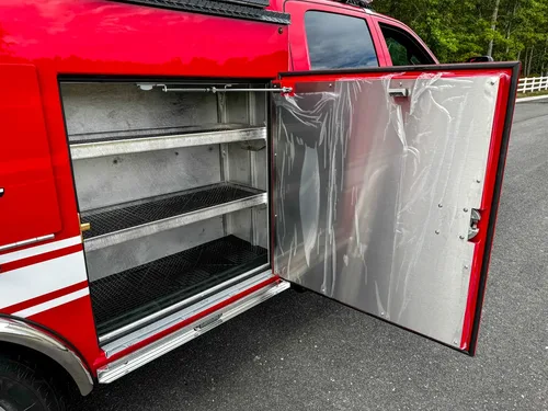 Open side compartment with multiple metal storage shelves.