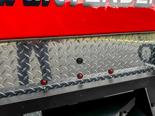 Rear diamond-plate edge with small marker lights.