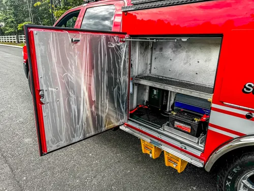 Open side compartment with mounted battery charger unit.