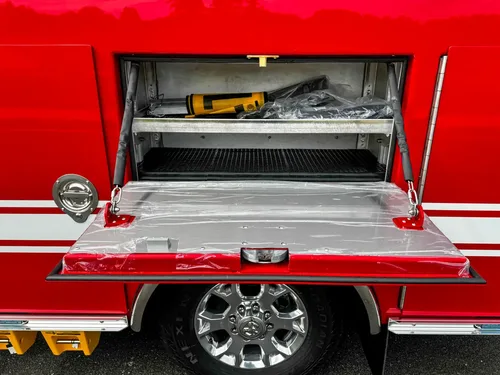 Open drop-down shelf compartment with tool mounted inside.