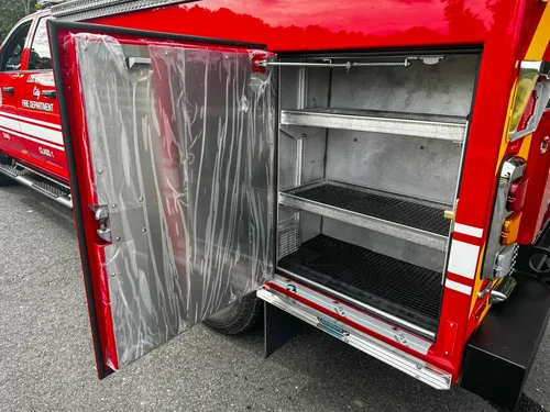 Open rear side compartment with mesh shelves and plastic cover.