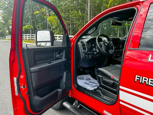 Open driver door showing front seat and dashboard.