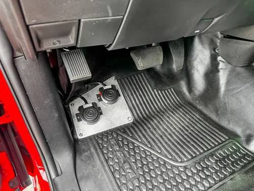 Driver footwell close-up with pedals and floor controls.