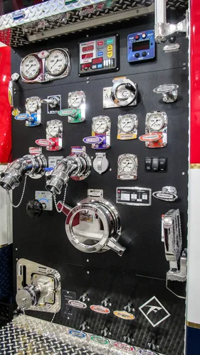Exterior view of small fire truck showing cab, body compartments, and wheel/tire area.