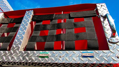 Exterior view of small fire truck showing cab, body compartments, and wheel/tire area.