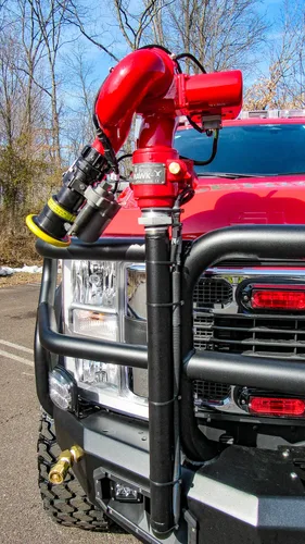 Exterior view of small fire truck showing cab, body compartments, and wheel/tire area.