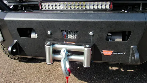Exterior view of small fire truck showing cab, body compartments, and wheel/tire area.