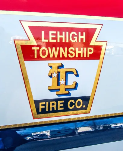 Exterior view of small fire truck showing cab, body compartments, and wheel/tire area.
