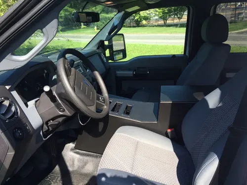 Exterior view of small fire truck showing cab, body compartments, and wheel/tire area.