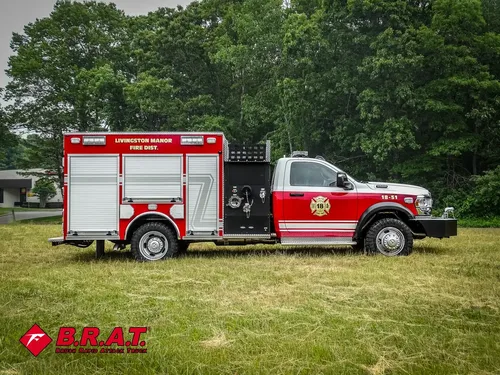 Exterior view of small fire truck showing cab, body compartments, and wheel/tire area.