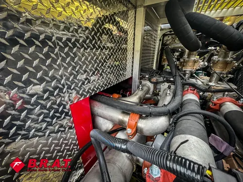 Exterior view of small fire truck showing cab, body compartments, and wheel/tire area.