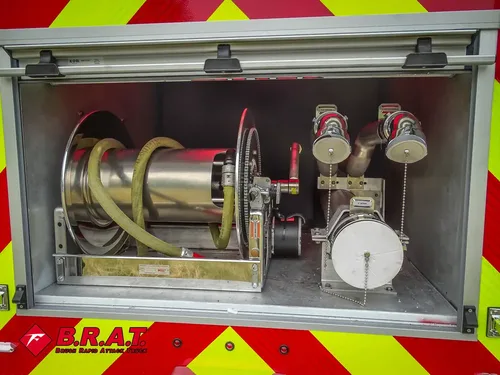 Exterior view of small fire truck showing cab, body compartments, and wheel/tire area.