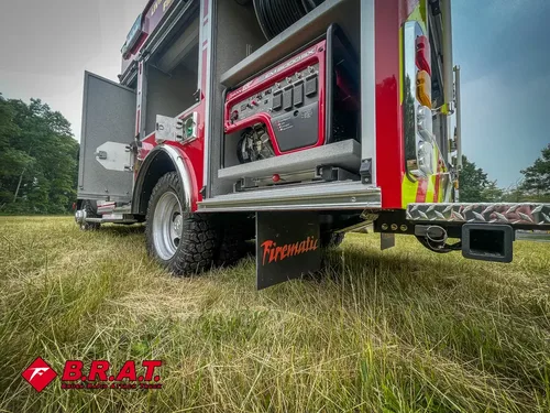 Exterior view of small fire truck showing cab, body compartments, and wheel/tire area.