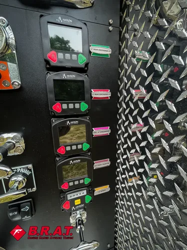 Exterior view of small fire truck showing cab, body compartments, and wheel/tire area.