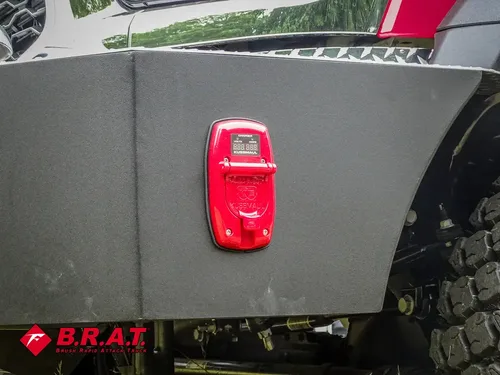 Exterior view of small fire truck showing cab, body compartments, and wheel/tire area.