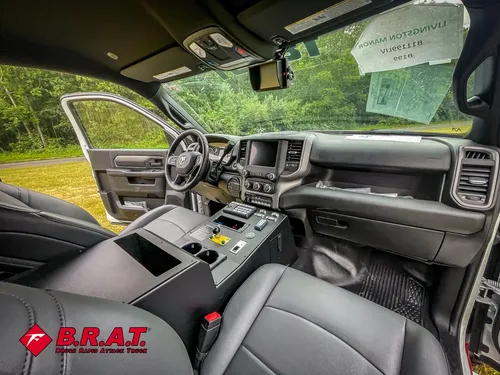 Exterior view of small fire truck showing cab, body compartments, and wheel/tire area.