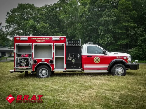 Exterior view of small fire truck showing cab, body compartments, and wheel/tire area.