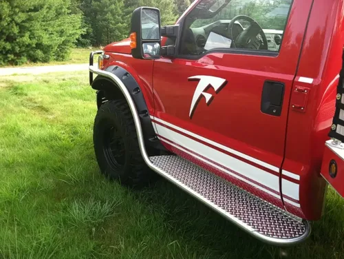 Exterior view of small fire truck showing cab, body compartments, and wheel/tire area.
