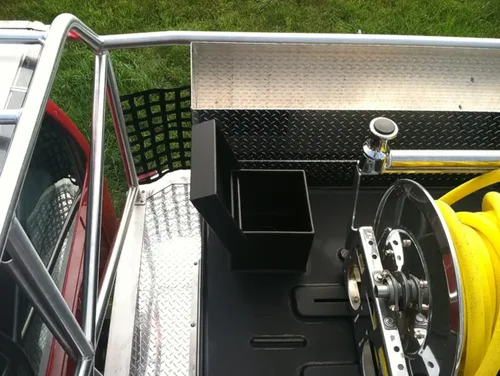 Exterior view of small fire truck showing cab, body compartments, and wheel/tire area.