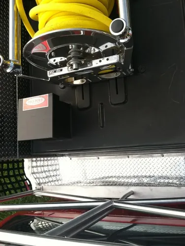Exterior view of small fire truck showing cab, body compartments, and wheel/tire area.