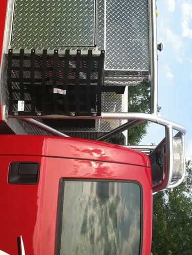 Exterior view of small fire truck showing cab, body compartments, and wheel/tire area.