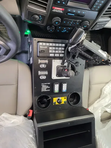 Exterior view of small fire truck showing cab, body compartments, and wheel/tire area.