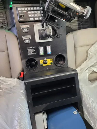 Exterior view of small fire truck showing cab, body compartments, and wheel/tire area.