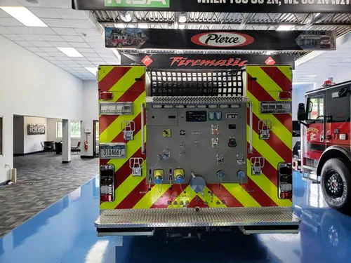 Exterior view of small fire truck showing cab, body compartments, and wheel/tire area.